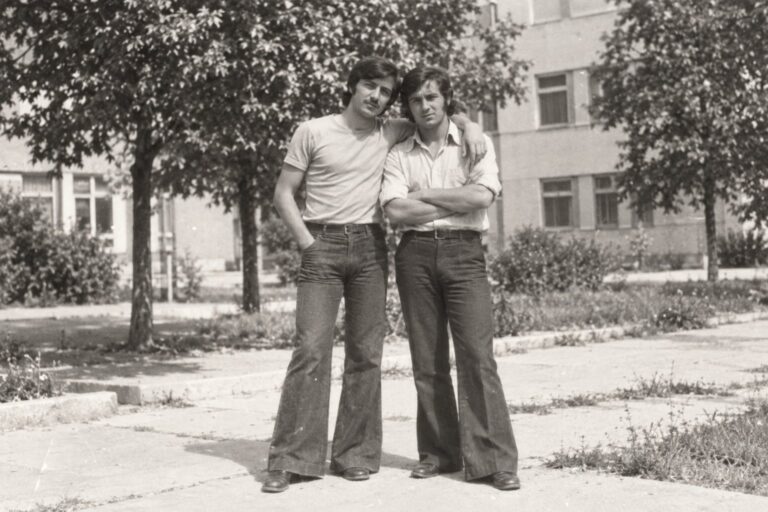 Doi prieteni cu pantaloni evazați, în parc (imagine generată cu AI)