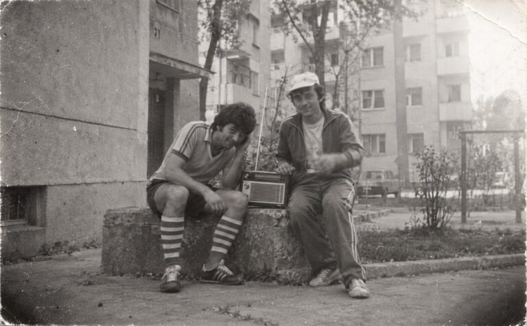 Doi tineri cu un radio, în fața blocului (imagine generată cu AI)