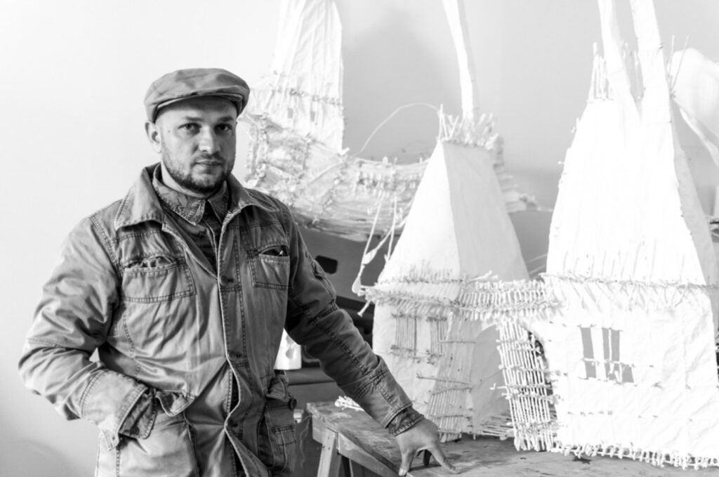 Sergiu Chihaia în atelier, lângă lucrările sale